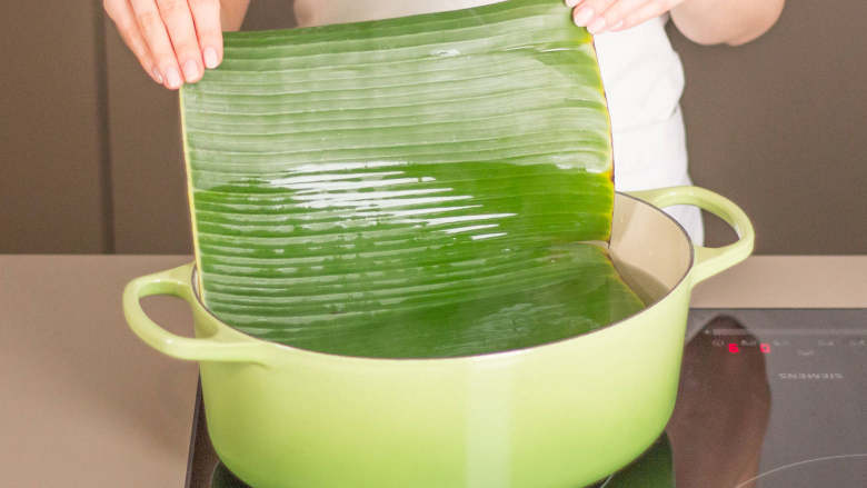 椰子脆鳕鱼,将香蕉叶剪成足以裹住鳕鱼片的大小。在大平底锅中加热水,不要煮沸。每次放入一片香蕉叶,煮2分钟,或直至叶子变软。