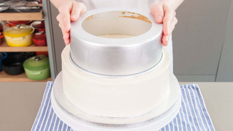 婚礼蛋糕,蛋糕凝固后,即可在蛋糕上根据你的个人喜好涂抹最后一层蛋白霜。然后,将蛋糕放回冰箱,冷藏1小时到24小时。蛋白霜凝固结实后,就要使用吸管固定这三层蛋糕。方法如下:将8英寸的蛋糕模居中地放在10英寸蛋糕层上,然后轻轻摁押烤模做上记号。在8英寸蛋糕层上也用6英寸烤模做相同操作。