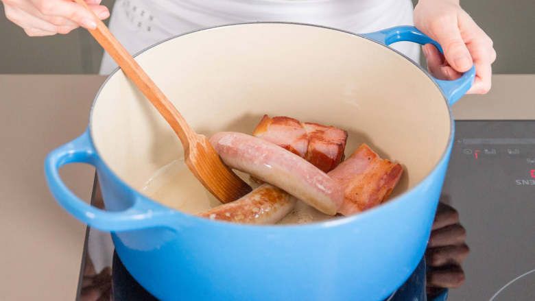 法式砂锅豆焖肉,在大煎锅中加热鹅油。烟熏猪排，<a style='color:red;display:inline-block;' href='/shicai/ 57122'>烟熏<a style='color:red;display:inline-block;' href='/shicai/ 438'>火腿</a></a>和香肠下锅炒至金黄，然后加入<a style='color:red;display:inline-block;' href='/shicai/ 438'>火腿</a>。