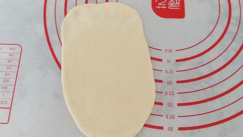 果酱奶酥排包,取一份醒好的小面团先擀成椭圆形,末端压薄然后卷起来,稍稍滚几下让它成长条状;