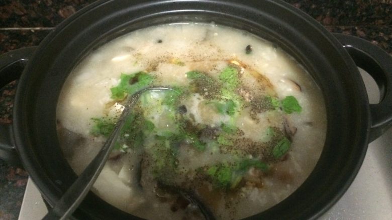 小米海鲜营养粥,撒上芹叶碎、胡椒粉,勺子拌匀。