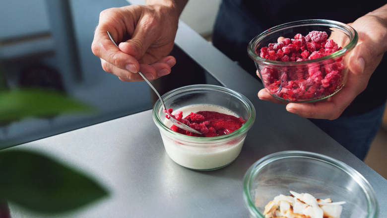 巴伐利亚奶油佐覆盆子酱,Return raspberry sauce to pan and reheat over medium heat. Add remainder of frozen berries to blender and pulse for approx. 10 – 15 sec. Garnish cream with raspberry sauce, frozen raspberry pieces, and toasted coconut flakes, if desired. Enjoy!