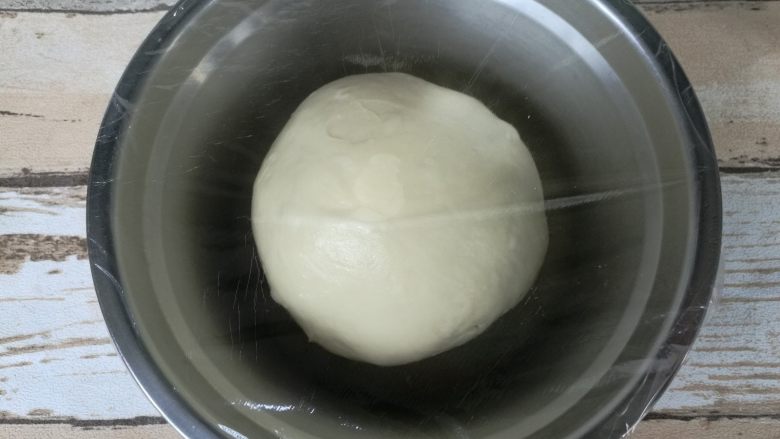 超好吃奶黄餐包,面团收圆,放盆内该保鲜膜进行基础发酵。