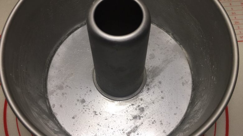 花环汉堡(植物油直接法),处理一下模具,这个是18cm中空阳极模,先用硅胶刷沾一点点植物油刷底部、四周、柱子,高度只要刷一半就足够了,然后撒上薄薄一层<a style='color:red;display:inline-block;' href='/shicai/ 28205'>高粉</a>,这样等下脱模就很轻松了