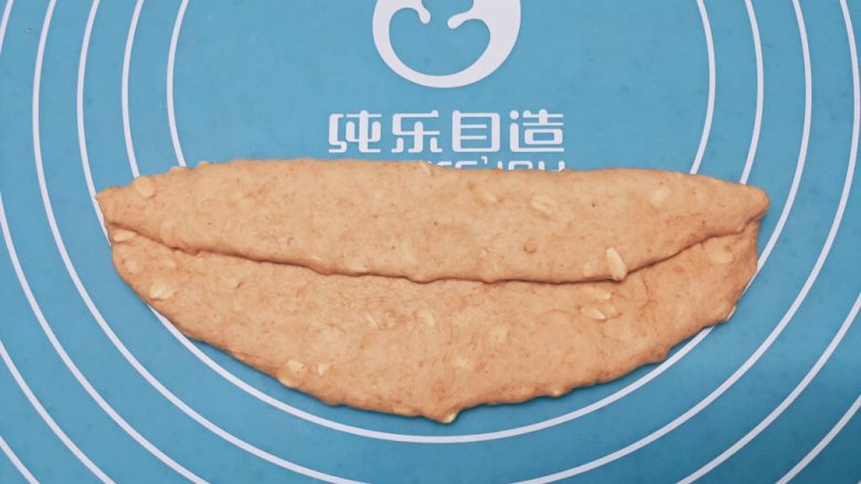 黑糖燕麦贝果,将翻面其横过来自三分之一处对折,拍紧