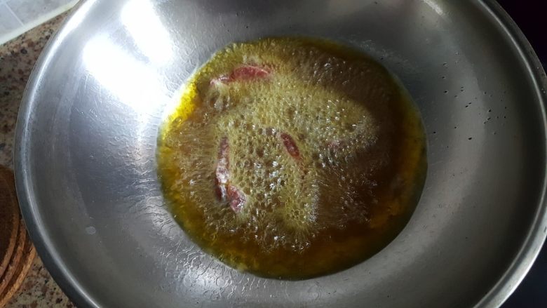 糖醋牛肉里脊,油热后,将里脊条一根一根地放入油锅中煎炸,炸好后盛出备用。