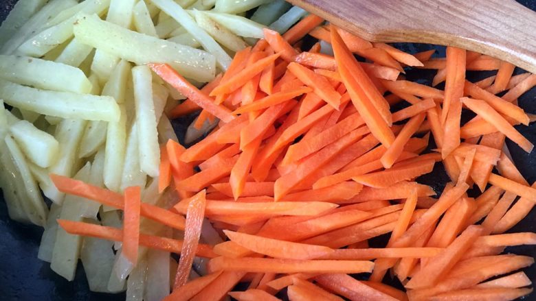 五彩土豆炒牛肉,倒入胡萝卜