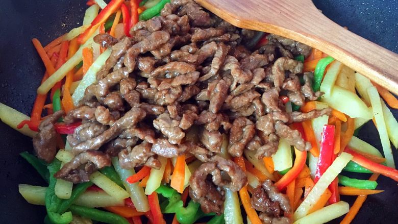 五彩土豆炒牛肉,再倒入牛肉，保持大火