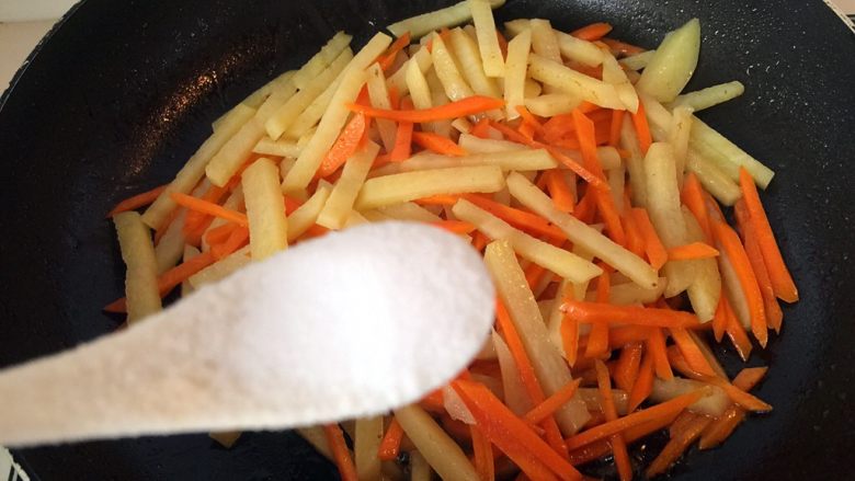 五彩土豆炒牛肉,炒制水份收干，转中火，放入一小勺盐