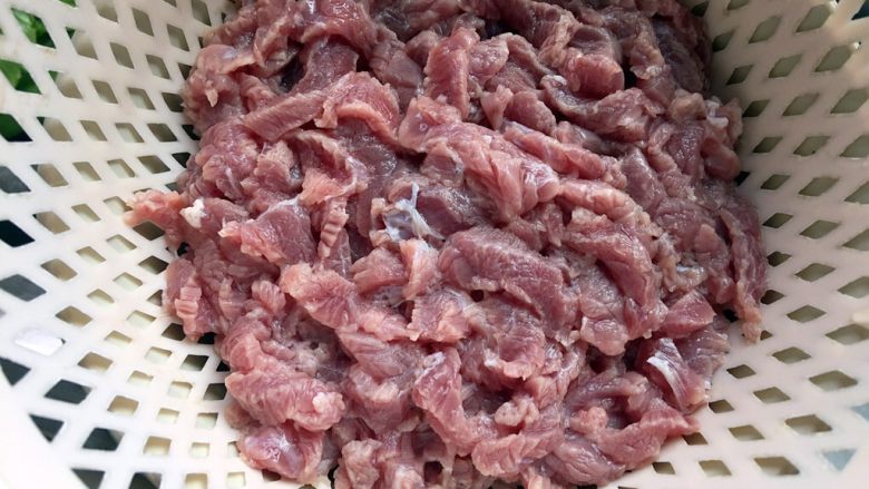 五彩土豆炒牛肉,将牛肉倒入小菜篓，在水龙头下冲洗一遍，沥去水分