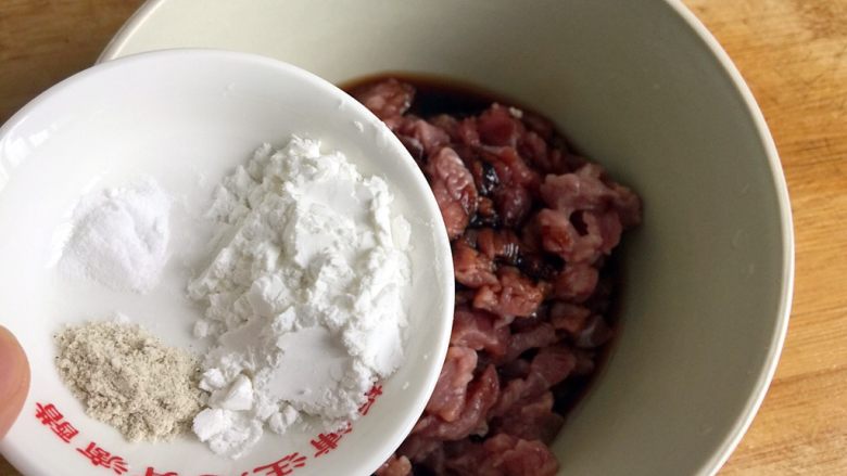 五彩土豆炒牛肉,将小苏打、白胡椒、淀粉倒入