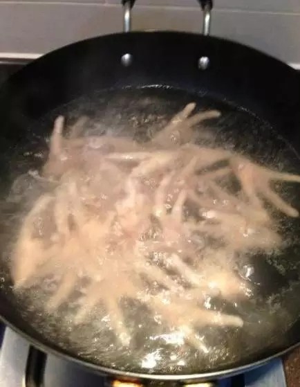 卤鸡爪,锅中热水,待水沸后,将鸡爪过沸水,把杂质捞掉