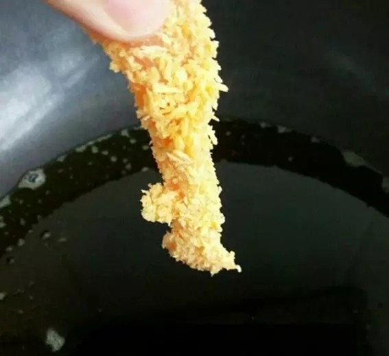 炸鸡柳,油热,放入裹好面包糠的鸡肉