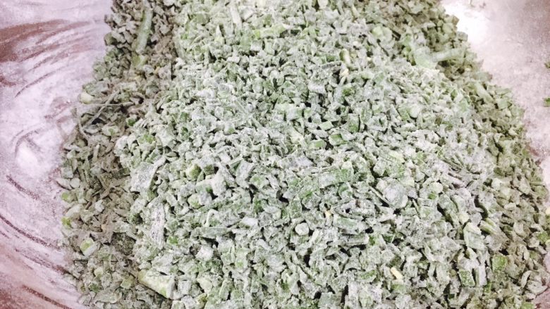 韭菜小圆子,分三次,每次放入一把面粉,把它们和匀,和好后每粒韭菜都沾上了一层薄薄的面粉。