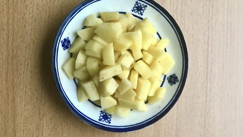 土豆苹果炖饭,土豆切丁。当午餐和晚餐可以切如图这么大,大概宽度1.5-1.8cm;早午餐尽量小一些,大约0.8cm的宽度。