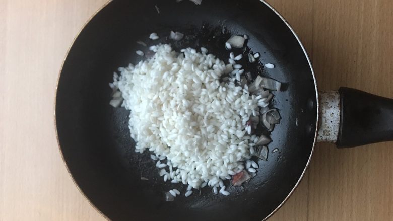 土豆苹果炖饭,加入生米。稍微炒一会,让培根香气进入大米中。