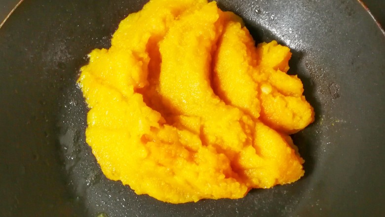 黄金土豆南瓜泥小饼,混合的土豆南瓜泥有些稀,在炒锅内倒入<a style='color:red;display:inline-block;' href='/shicai/ 851'>橄榄油</a>,放入泥类小火翻炒,加入少许干淀粉至炒匀,