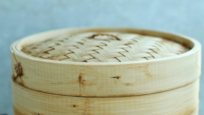 东北猪肉酸菜馅包子,蒸锅中添适量水,将蒸笼置于锅上,大火烧开后蒸十五分钟