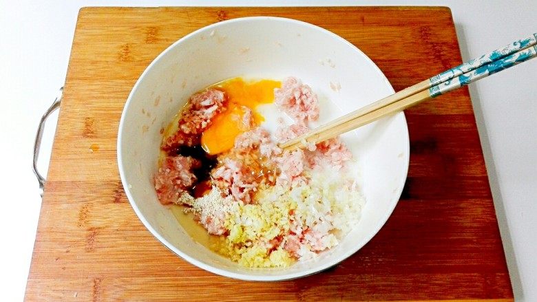 金山银海~秀珍菇肉圆汤,把鸡蛋,糖,盐,鸡精,生抽,蚝油大葱碎,姜末,玉米淀粉水都加到肉糜碗里