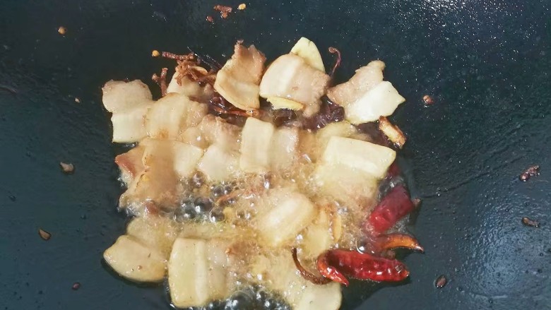 萝卜干烧五花肉,再放入五花肉片,煸至燋黄出油;