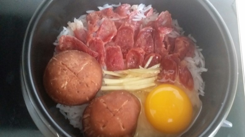 腊味煲仔饭,打入<a style='color:red;display:inline-block;' href='/shicai/ 9'>鸡蛋</a>,加盖小火煮15分钟
