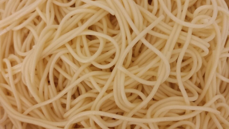 川味凉面,面条沥干水。放入芝麻油。多放点用筷子把面条拌匀