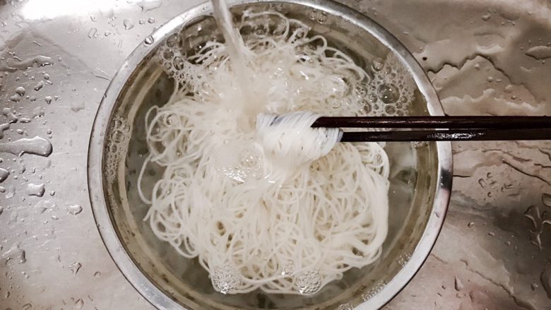 香菇茄子焖面,捞出来的面条,用冷水一直冲,冲到碗里的水不烫了,就让面条在水里面躺着待用