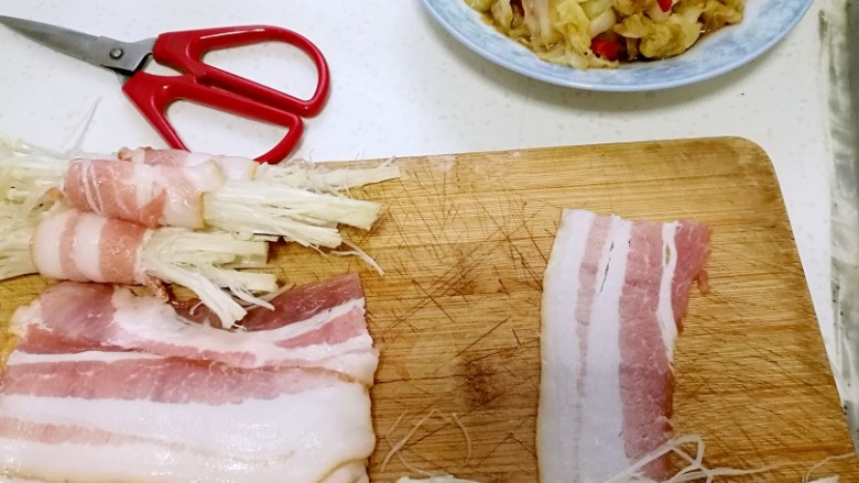 培根金针菇卷,开始包啰！一定要把金针菇挤干水份再包，尽量包紧点