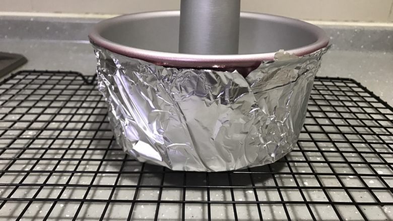 蓝天白云戚风,这类造型戚风蛋糕最重要的是不能上色,所以在模具周围包一层锡纸。包上锡纸后隔了一部分热,所以烤的时间要比普通戚风时间长一些。