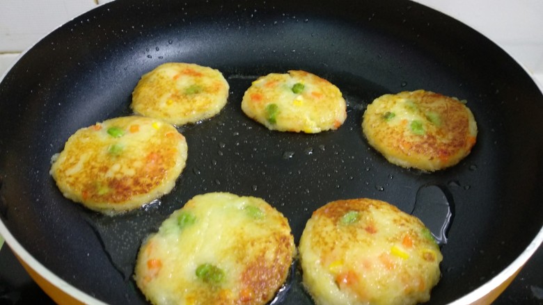 田园土豆饼,热锅倒入适量植物油烧七成热,逐一放入土豆饼,煎至两面金黄即可。(煎的过程用铲子时不时移动,让其受热均匀。翻面动作要轻,以免变形,如变形的话用铲子整理即可。)