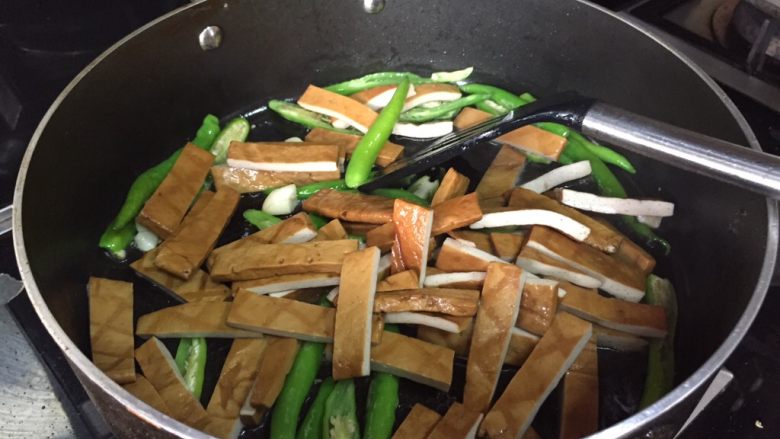 青椒炒豆腐干,倒入香干,翻炒;