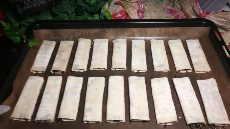 脆皮芝麻海苔,烤盘上放油布,封口朝下放的目的是烤制时定型。朝上放,烤的时候会卷起来。