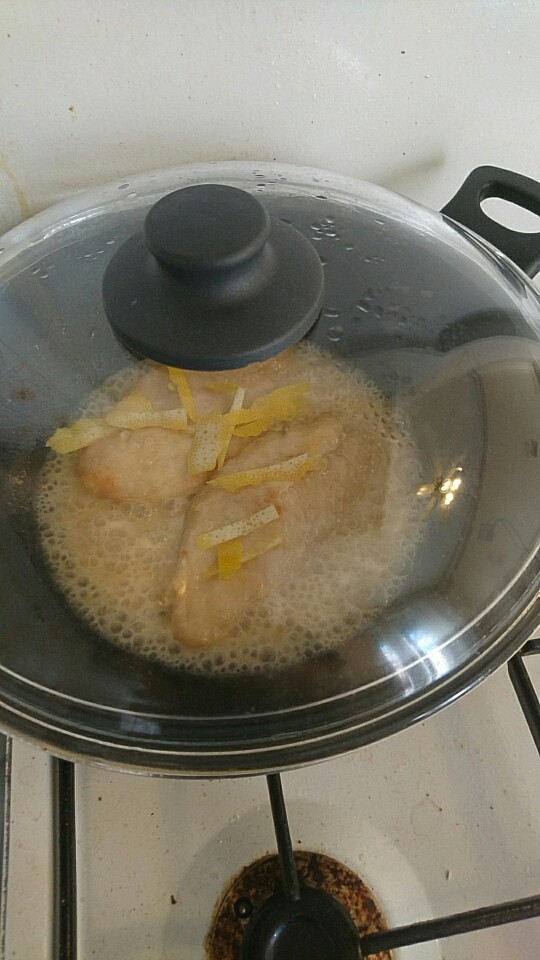 柠檬鸡胸肉,盖上锅盖小火煮三分钟,然后翻面把之前准备好的柠檬皮洒在鸡肉上面继续煮,热量会让柠檬散发出香气,加上我们不需要着急收汁,所以最好盖上锅盖慢煮