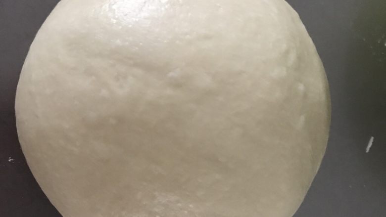 椰子味酥粒芒果面包,排气后再次滚圆,盖保鲜膜松弛15分钟。