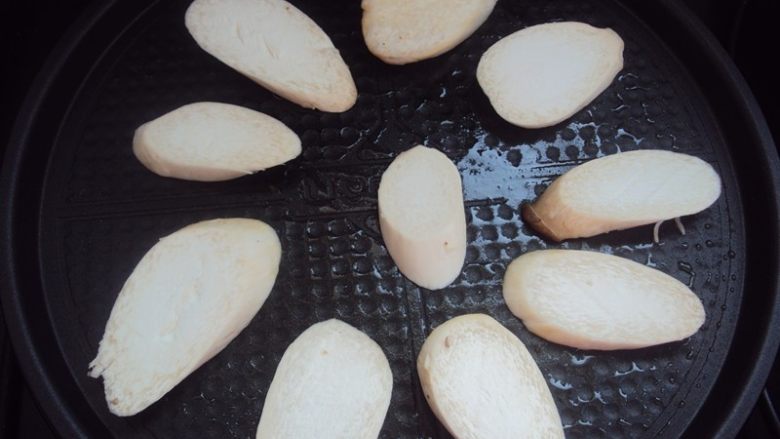 椒香杏鲍菇,把切好的杏鲍菇放入饼铛,盖上煎烤