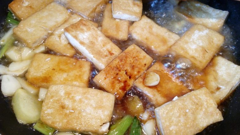 菌茹烩豆腐,倒入半碗高汤,大火烧开,加入一小勺盐,小火焖煮5分钟让豆腐入味。