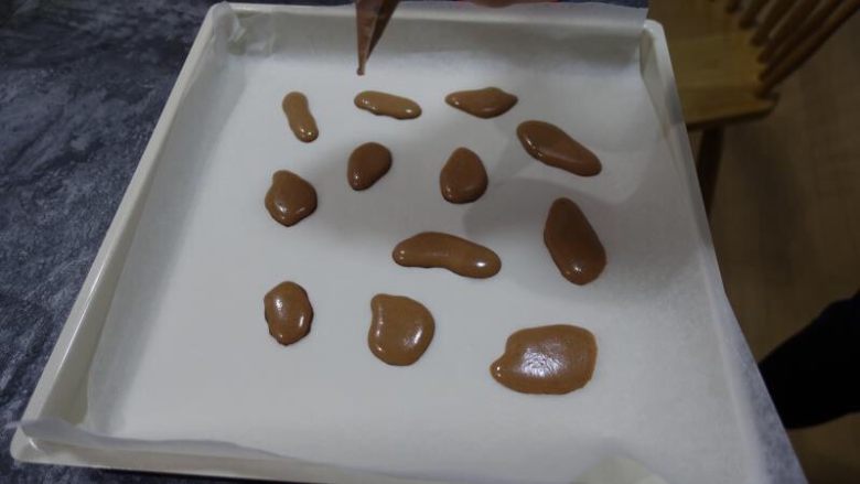 奶牛蛋糕卷(后蛋法),巧克力面糊装进裱花袋,剪一个小口,挤出不规则牛奶斑纹