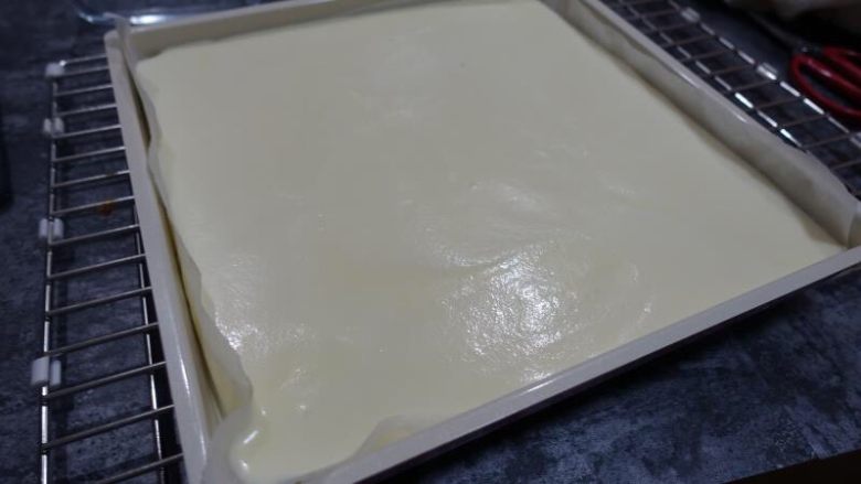 奶牛蛋糕卷(后蛋法),借用刮板刮平表面,再轻震几下,去除表面大气泡。