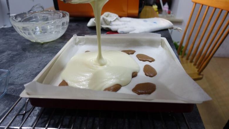 奶牛蛋糕卷(后蛋法),放入烤箱1分钟左右,表面凝固以后可以拿出来,面糊从高处倒入垫了烘焙纸(或者硅胶垫)的28*28金盘中,