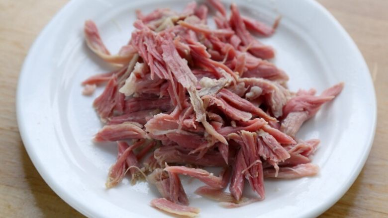 西红柿土豆浓汤,4.将汤稍微加热,取出肘子瘦肉,撕成丝。