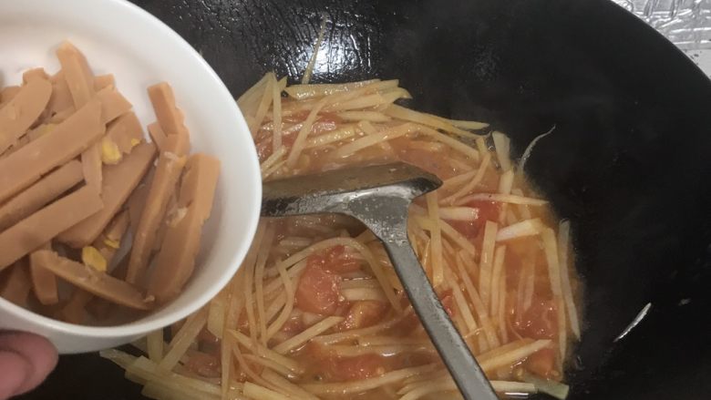 火腿番茄土豆丝,等土豆熟后，下入火腿肠翻炒，使火腿肠能均匀拌上番茄汁