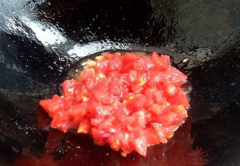 百塔西红柿:海鲜大红虾意面,加入番茄丁继续炒。