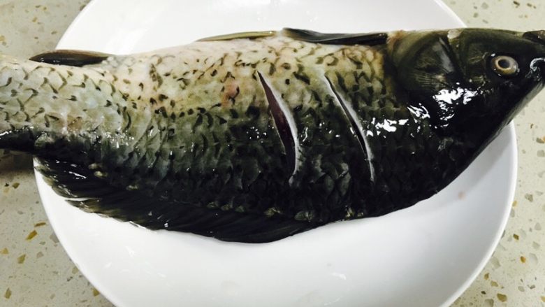 美味的红烧鱼,正背面划两刀,将姜片塞进去划开的鱼缝里。