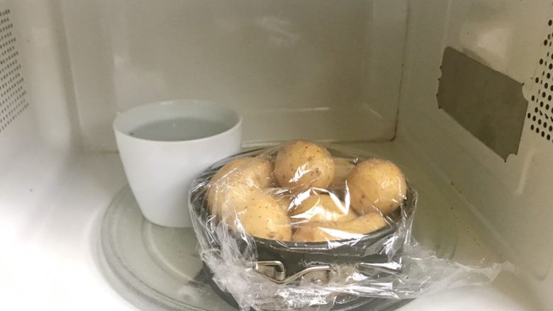 椒盐土豆,依旧是包上保鲜膜,和一碗水放入微波炉中叮。要叮8分钟,各个微波炉功率可能有所不同,有些可能需要更长大约10分钟。不管怎样一定要熟透。
