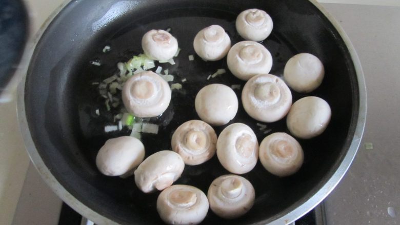 口蘑烩豆腐圆子,热锅凉油, 放入姜葱蒜末爆香;