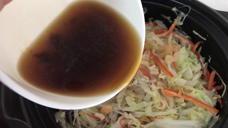 虾米粉丝煲,倒入刚才调制好的酱汁,如果觉得酱汁少可以再加点青水一起,翻炒均匀后