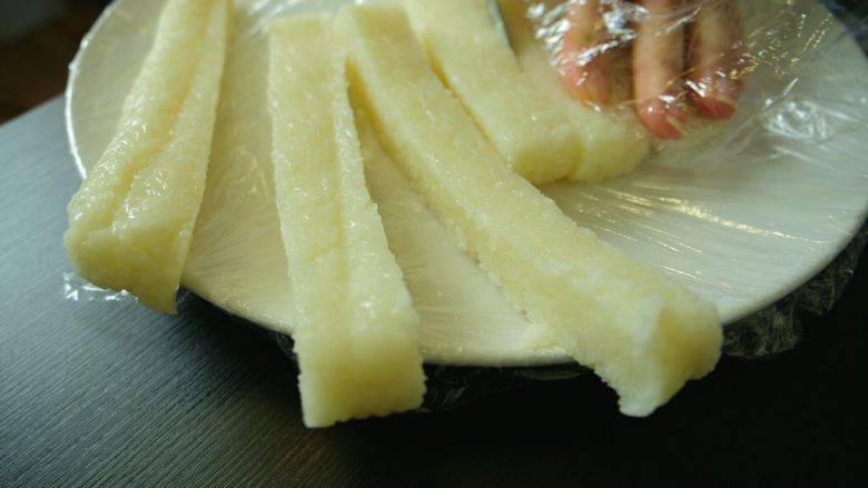 红糖糍粑,还记得糯米底下和上面的保鲜膜吗?手放在保鲜膜上,方便使力同时也不会粘手~