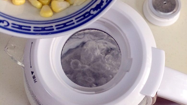 玉米圆子甜酒酿,待水烧开,把剥好的玉米粒倒入壶内。