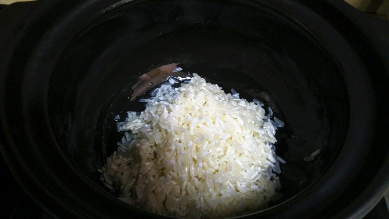 豆角煲仔饭,把<a style='color:red;display:inline-block;' href='/shicai/ 492'>大米</a>掏一下后,倒入砂锅里。