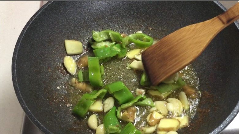 销魂辣子鸡,倒入姜蒜青椒炒出香味